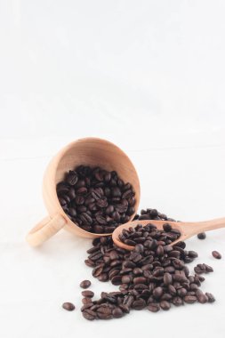 Beyaz arka plan üzerinde ahşap Kupası kahve çekirdekleri izole