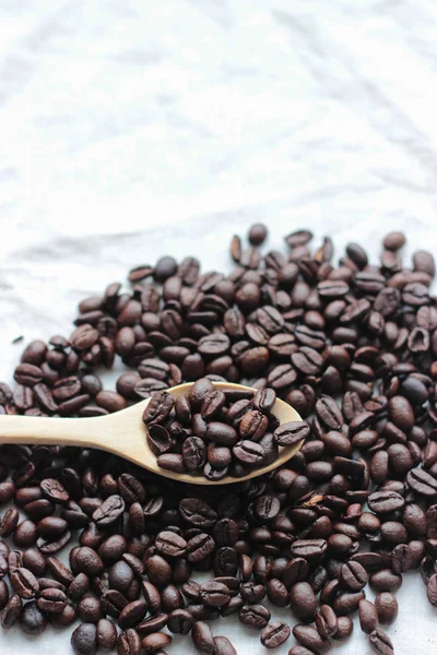 Chicchi di caffè cucchiaio di legno su sfondo mucchio — Foto Stock