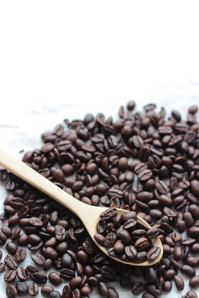 Chicchi di caffè cucchiaio di legno su sfondo mucchio — Foto Stock