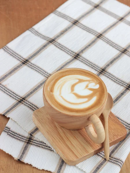 Café arte tardia em xícara de madeira na bandeja e vestuário, com colher — Fotografia de Stock