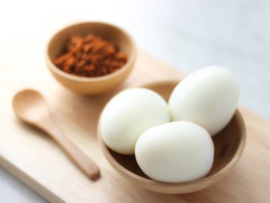 Küçük ahşap tabak ve kaşık Chili yapıştır ile haşlanmış yumurta 