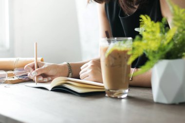 Kapalı siyah elbiseli Asyalı kadın boş defter B 'ye yazılmış.
