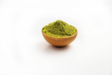 Kapalı makro nesne, çıkarılmış yeşil çay tozu yığınını beyaz arka planda tahta kasede izole et. Bu en iyi doğal malzemeler Tayland 'ın kuzeyindeki tarladan gelen kuru yeşil çay izinlerinden elde edilir..