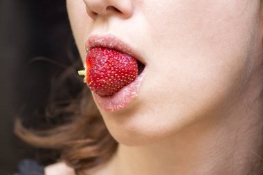 Dudakları temizlemek için evde çilekli dudak fırçalama. 