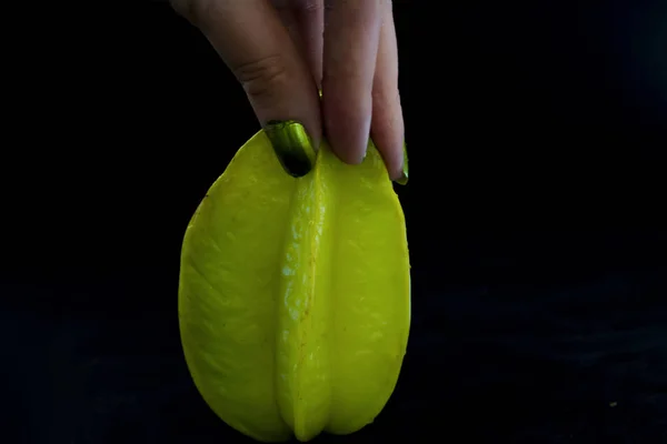 A star fruit carambola on a black background