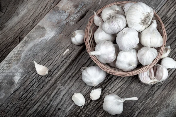 Fresh organic garlic in wicker basket — Stock Photo, Image