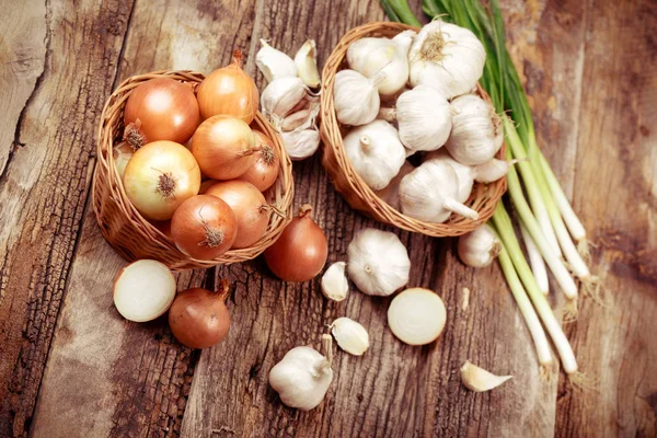 Organic onion, spring onion and garlic in wicker basket