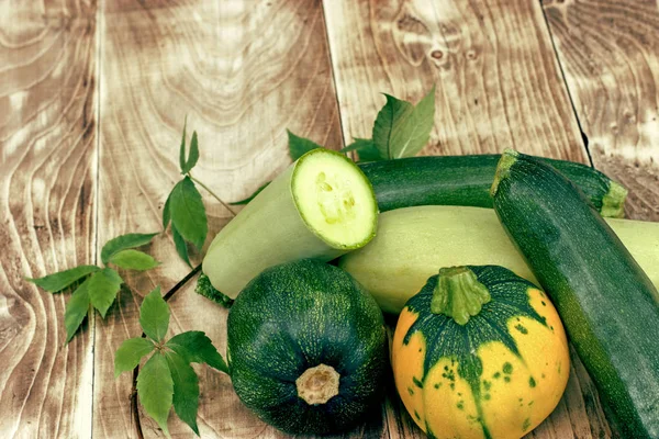 Zucchini, marrow squash and pumpkin on rustic wooden table