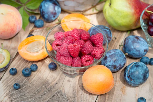 Fresh organic raspberries and other seasonal fruits — Stock Photo, Image