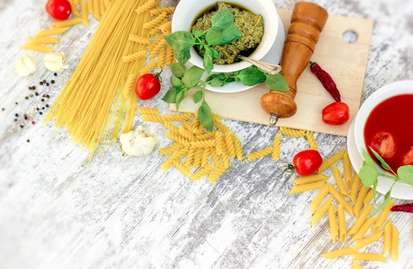 Homemade basil pesto sauce, tomato sauce and ingredients for healthy, delicious meal on table — Stock Photo, Image