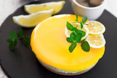 Kremalı limonlu peynirli kek ve kırsal tabakta kahve.