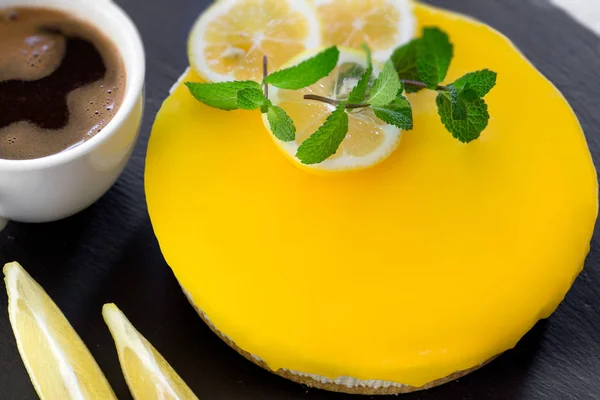 Creamy cheesecake, lemon cheesecake on black rustic plate closeup