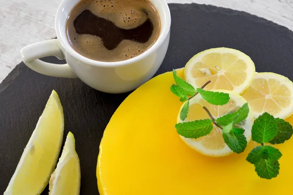 Lemon cheesecake and cup of coffee on table