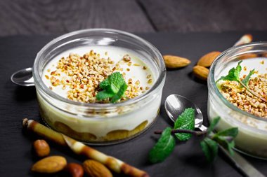 Kırsal masada cam kasede kremalı peynirli kek, fındıklı kremalı peynirli kek.