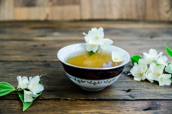 jasmine tea with jasmine flowers on wooden background