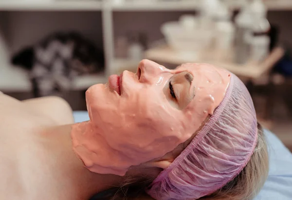 Woman with peel off face mask on her fase.