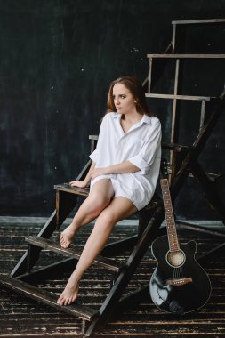 Beyaz adam tişörtlü esmer kız bir çatı katında..