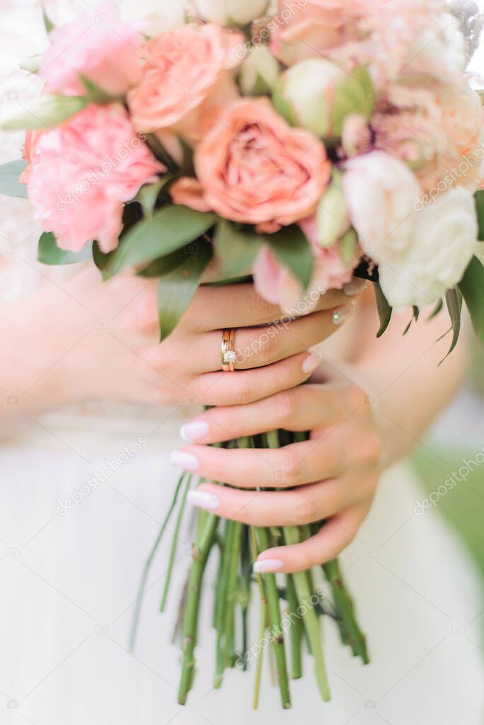 Delicate light bouquet of the bride in the hands. Summer wedding floristics and decor. Engagement ring, engagement.