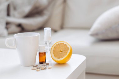 Evdeki masada hastalığa karşı ilaçlar var. Bir fincan çay, temel yağ, limon, hap ve ilaç. Yatak istirahati. Virüs, soğuk, öksürük, soğuk, bakteriyel.