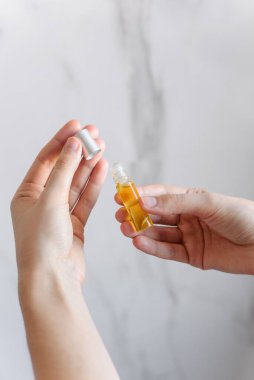 Beyaz mermer bir arka planda el yapımı Aromatik yağ parfümleri. Sarı kokoba yağı ve gerekli yağ. Tekerlekli şişe..