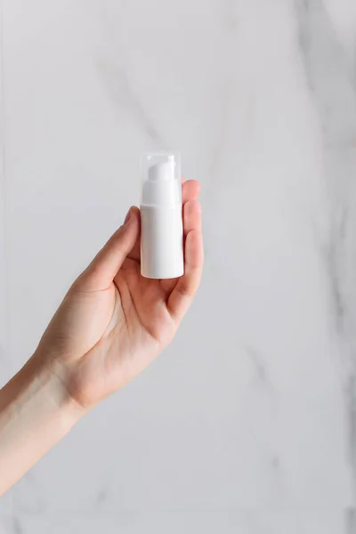 White Bottle Cream Its Hand White Marble Background Isolated Object — Stock Photo, Image