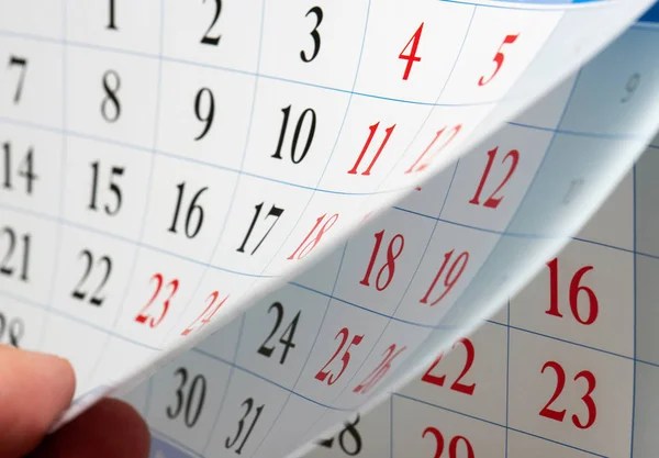 Fingrar håller bladet kalender — Stockfoto