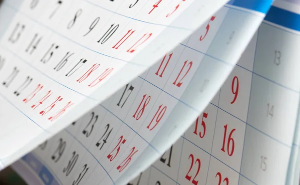 Переворачивание календарных листов с черными и красными цифрами — стоковое фото
