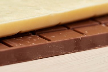 Beyaz lezzetli çikolata siyah çikolata portre üzerinde yatıyor