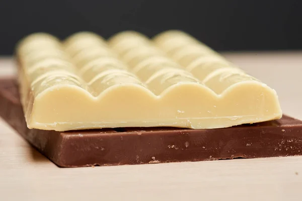 White delicious porous chocolate lies on the black one — Stock Photo, Image