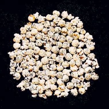 Siyah parlak arka plan en az moda üzerinde patlamış mısır