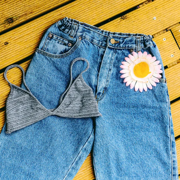 Calça jeans azul vintage e sutiã em um fundo de madeira — Fotografia de Stock