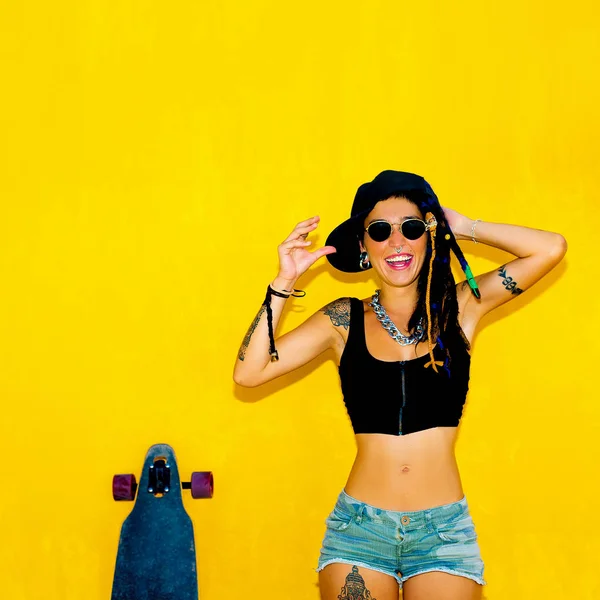 Cool gelukkig meisje met dreadlocks, piercings en longboard over co — Stockfoto