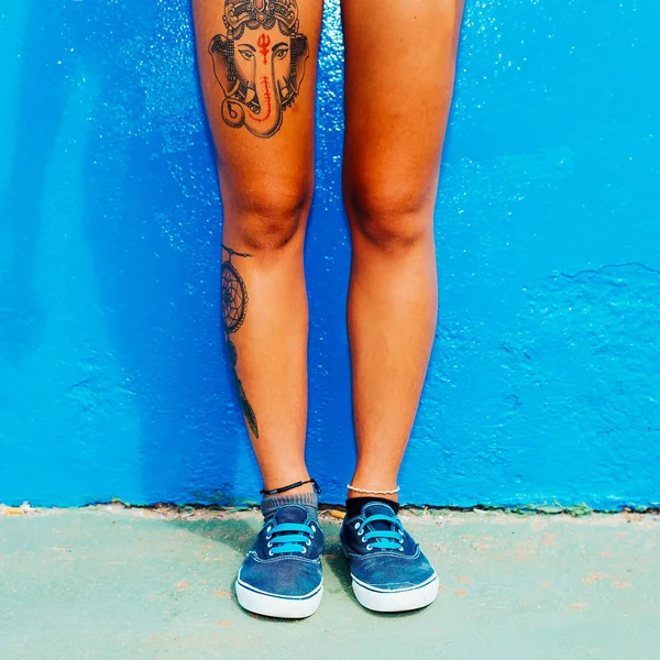 Испанская девушка с татуировкой и стильной обувью на голубой стене. Ska — стоковое фото