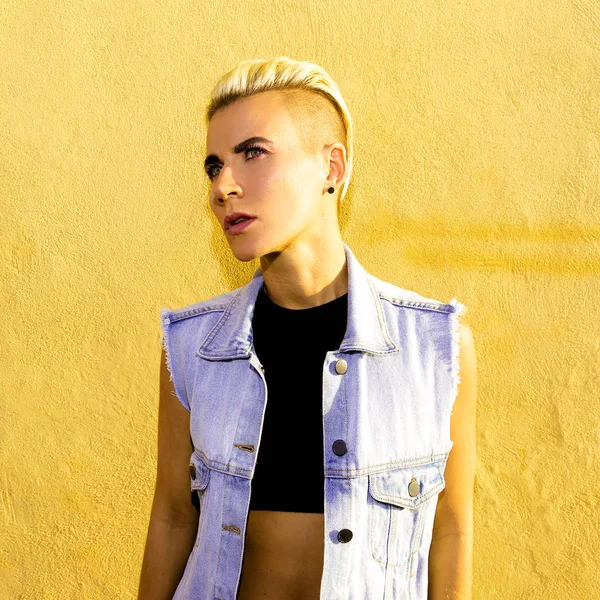 Şık denim kıyafetiyle şehirde kısa saçlı sarışın