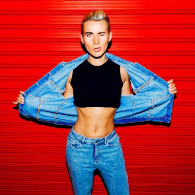 Şık model kırmızı bir arka plan üzerinde kot kıyafeti. Sokak stili