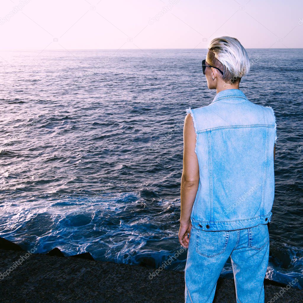 Model in stylish denim outfit sea background sunset