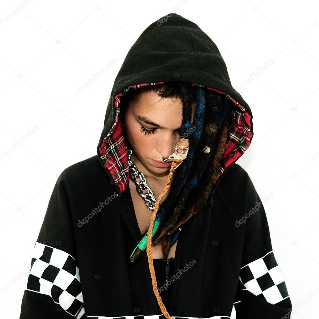 Girl in a sweatshirt with dreadlocks and piercings. Fashion acce