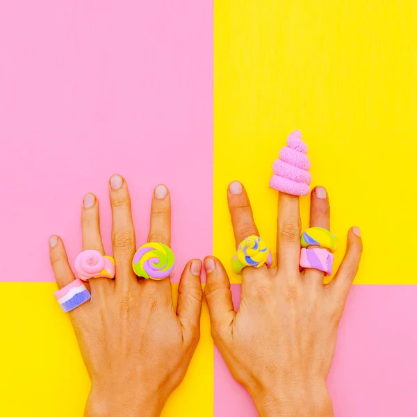 Hands in candy accessories. Minimal sweet mood. Vanilla fashion