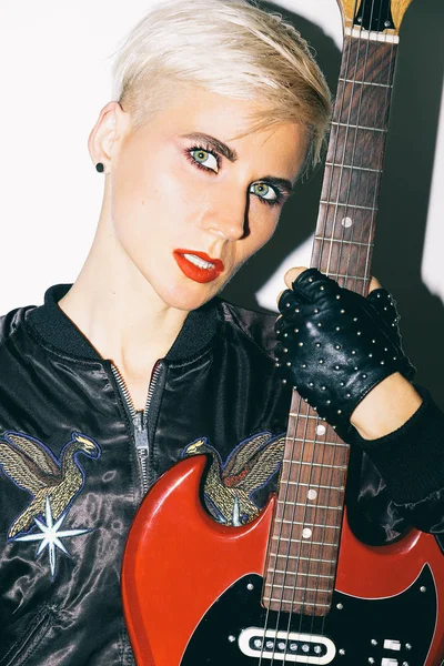 Blonde Girl with electro guitar. Rock fashion style