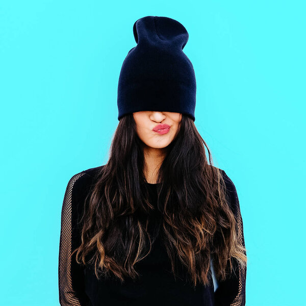 Emotional brunette in black beanie cap. Stylish urban look