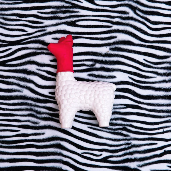 Lembrança de brinquedo Llama em fundo de impressão zebra. Arte mínima — Fotografia de Stock
