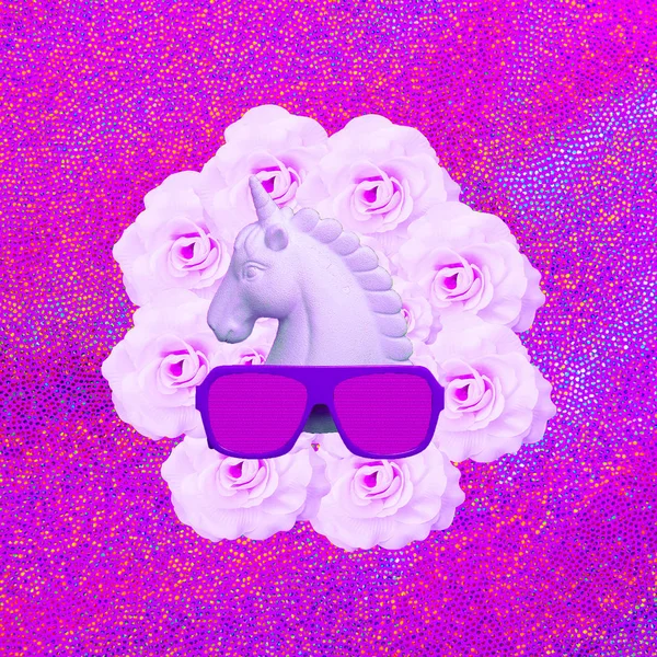 Branco unicórnio pintado e óculos de sol elegantes no espaço rosa flor — Fotografia de Stock