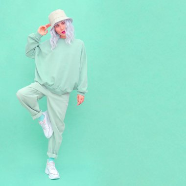 Stüdyoda poz veren hippi kız. Şehir tarzı. Hip-hop. Taze moda nane tek renkli estetik renkler.