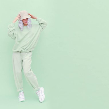 Stüdyoda poz veren hippi sarışın kız. Şehir tarzı. Hip-hop. Taze moda nane tek renkli estetik renkler.