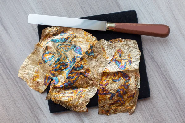 Gilding theme with a leaf of beaten gold and blade — Stock Photo, Image