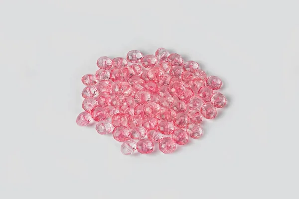 Perles acryliques roses sur fond blanc — Photo