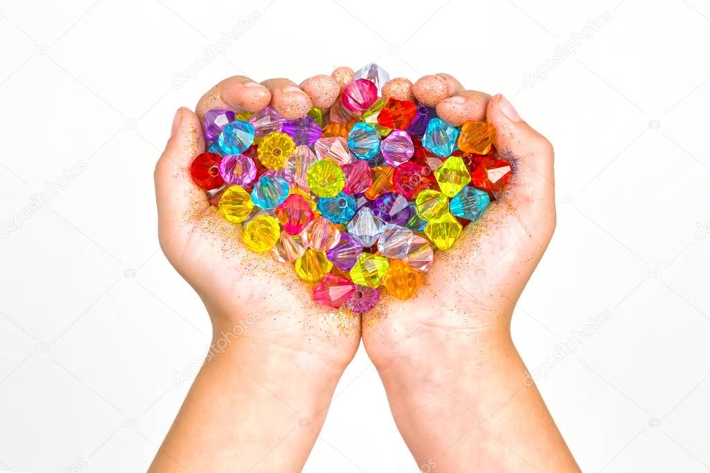 childrens hands, hands holding beads on a white background