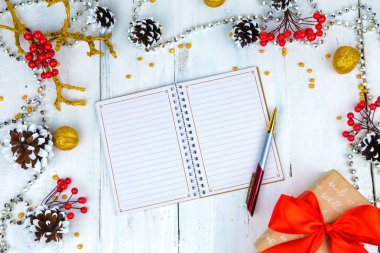 Noel ahşap arka plan koniler ve Not Defteri ile. Not defterinde yazmak eller.