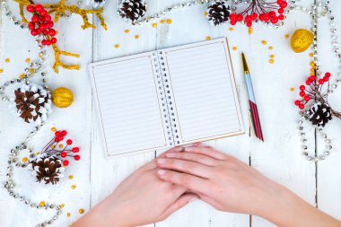 Noel ahşap arka plan koniler ve Not Defteri ile. Not defterinde yazmak eller.