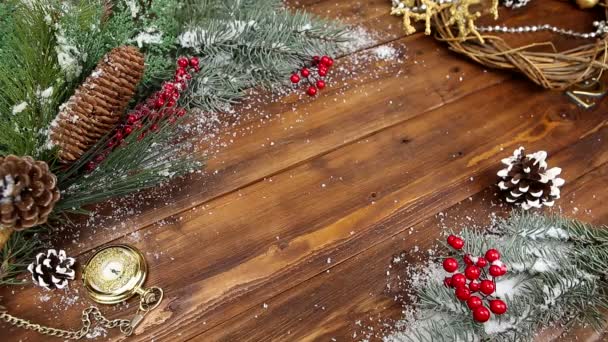 Weihnachten hölzernen Hintergrund mit verschneiten Zweig Draufsicht. die Hände eines jungen Mädchens legen ein Geschenk mit roter Schleife auf den Tisch — Stockvideo